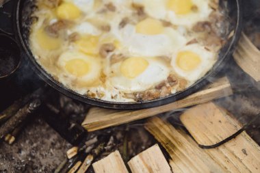 Kamp gezisinde kamp ateşinde yemek pişirdim. Kamp mutfağı, ormanda ateş içinde yemek pişirmek. Kızartma tavası yanıyor. Kamp hayatı konsepti.