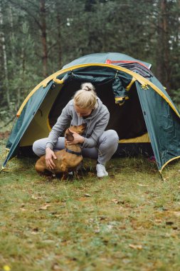 Kamp gezisinde köpeği olan genç bir kadın. Kamp hayatı konsepti.