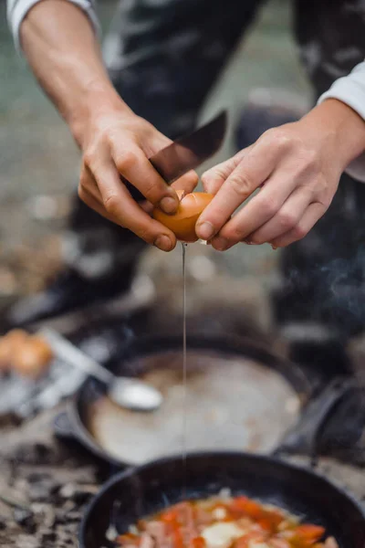 Cooked food on a campfire on a camping trip. Camp kitchen, cooking food in the forest on fire. Frying pan on fire. Camping life concept.