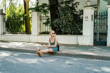 Güneşli bir yaz günü, güzel genç bir kadın sokakta dondurma yiyor..