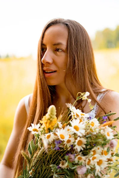 若い美しい女性は白いドレスと帽子で長い髪をウィットライ麦と小麦の黄色のフィールドの間で 開花場の白い太陽の下で長い髪の素朴なスタイルのコンセプト — ストック写真
