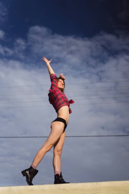 Genç kadın gökyüzüne karşı fiziksel olarak iyi durumda, baraj.