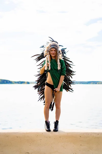 woman wearing an American Indian hat. Close up portrait of shamanic female with Indian feather hat