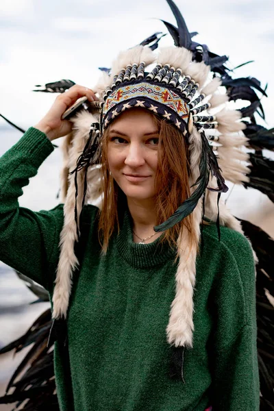 woman wearing an American Indian hat. Close up portrait of shamanic female with Indian feather hat