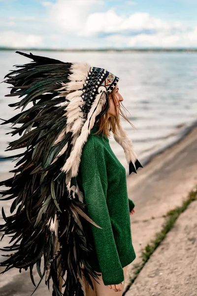 woman wearing an American Indian hat. Close up portrait of shamanic female with Indian feather hat