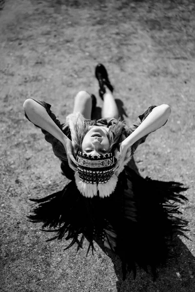 woman wearing an American Indian hat. Close up portrait of shamanic female with Indian feather hat