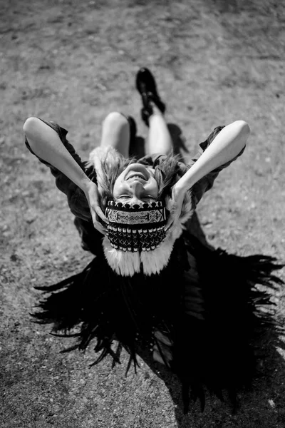 woman wearing an American Indian hat. Close up portrait of shamanic female with Indian feather hat