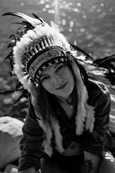 woman wearing an American Indian hat. Close up portrait of shamanic female with Indian feather hat
