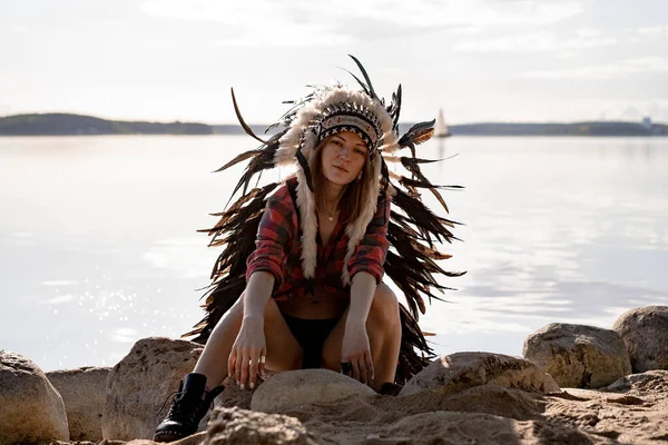 woman wearing an American Indian hat. Close up portrait of shamanic female with Indian feather hat