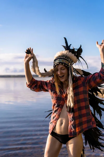 woman wearing an American Indian hat. Close up portrait of shamanic female with Indian feather hat