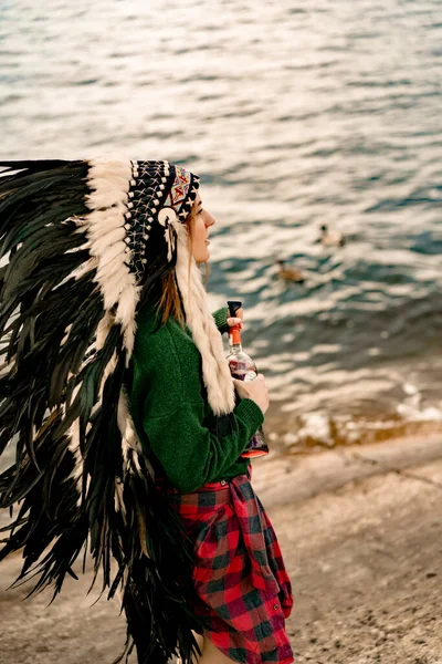 woman wearing an American Indian hat. Close up portrait of shamanic female with Indian feather hat