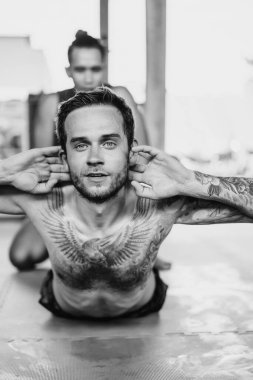 Ringde Muay Thai antrenörüyle antrenman yapmak. Dövmeli beyaz adam ve Asyalı antrenör. Muay thai eğitimi.