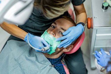 Kofferdam hastası bir dişçi tarafından tedavi ediliyor.