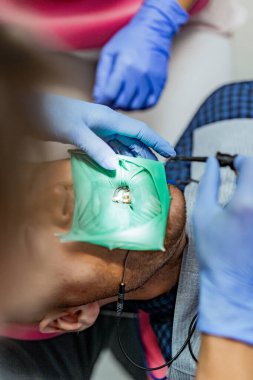 Kofferdam hastası bir dişçi tarafından tedavi ediliyor.