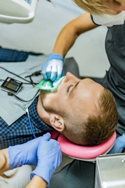 Kofferdam hastası bir diş hekimi tarafından tedavi ediliyor.