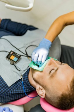 Kofferdam hastası bir diş hekimi tarafından tedavi ediliyor.