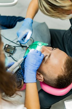 Kofferdam hastası bir diş hekimi tarafından tedavi ediliyor.