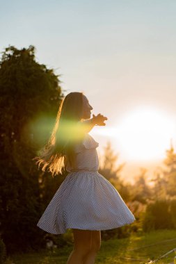 Kırsalda vakit geçiren genç bir kadın, Nat 'te günbatımı eğlencesi.