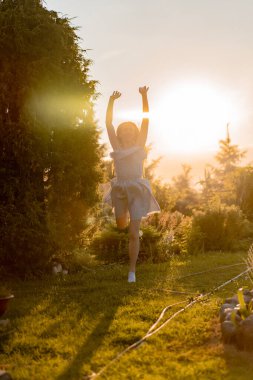 Kırsalda vakit geçiren genç bir kadın, Nat 'te günbatımı eğlencesi.