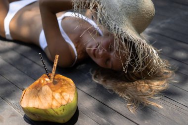 Hindistan cevizi suyu içen çekici genç bir kadının portresi. Mutlu