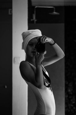 Kameralı güzel genç bir kadın aynada selfie çekiyor.