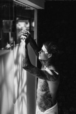 Banyoda duş aldıktan sonra dövmeli yakışıklı bir genç. 