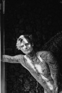 Duşta dövmeli yakışıklı bir genç. yaşam tarzı konsepti. 