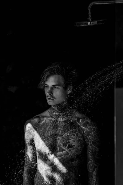 シャワー中のタトゥーのハンサムな若い男 ライフスタイルのコンセプト — ストック写真