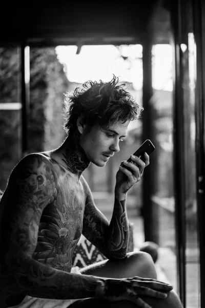 Przystojny Młody Mężczyzna Tatuażach Mówi Przez Telefon Głośnomówiący — Zdjęcie stockowe