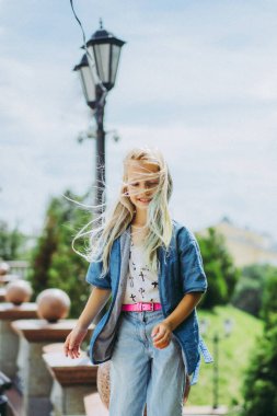 Güzel bir kız, uzun sarı saçlı, portre, yakın plan, dışarıda. Renkli saçlı bir kızın portresi..