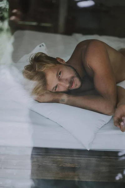 Seksi Çıplak Genç Adam Yatakta Yatarken Kameraya Bakıyor — Stok fotoğraf