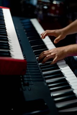 male musician plays the synthesizer on stage.