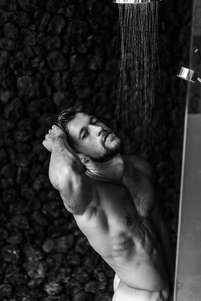 シャワーを浴びてる男はシャンプー製品で髪を洗う — ストック写真