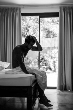 Yatakta yakışıklı bir adam sabah uyanır. Genç adam uyuyor.