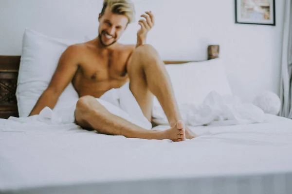 Sexig Naken Ung Man Tittar Kameran När Han Ligger Sängen — Stockfoto