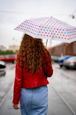 Şemsiyenin altında uzun saçlı genç ve güzel bir kadın. Sonbahar konsepti.