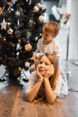 Çocuklar Noel ağacını süsler, erkek ve kız kardeşler tatil için evi dekore ederler. Noel tatili. Mutlu Noeller ve mutlu yıllar konsepti.