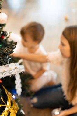 Çocuklar Noel ağacını süsler, erkek ve kız kardeşler tatil için evi dekore ederler. Noel tatili. Mutlu Noeller ve mutlu yıllar konsepti.