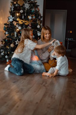 Mutlu çocuklar Noel ağacında oynar ve eğlenir.,