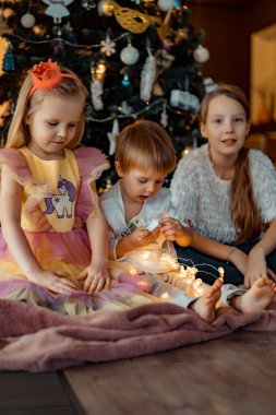 Mutlu çocuklar Noel ağacında oynar ve eğlenir.,