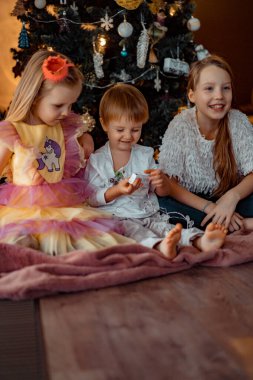 Mutlu çocuklar Noel ağacında oynar ve eğlenir.,