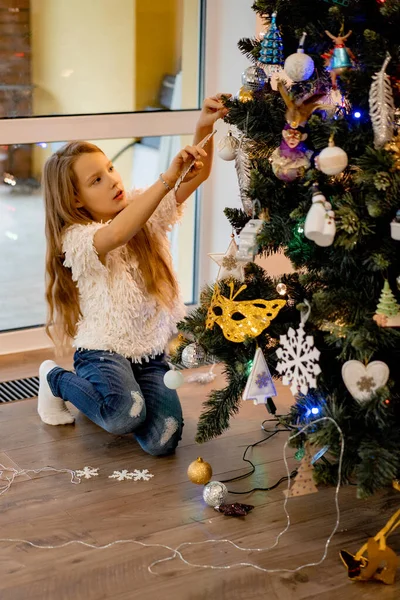 Una Niña Pequeña Decora Árbol Navidad Con Guirnaldas Juguetes Los —  Fotos de Stock