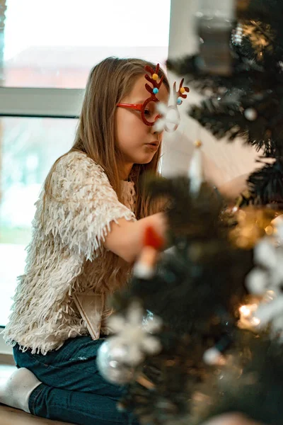 Una Niña Pequeña Decora Árbol Navidad Con Guirnaldas Juguetes Los — Foto de Stock