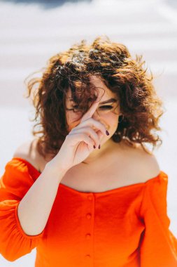 Kırmızı elbiseli, kıvırcık siyah saçlı güzel bir kadının portresi. dışarıName.