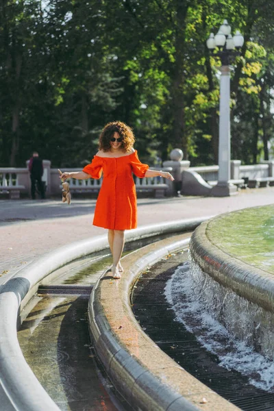 Krásná Žena Kudrnaté Tmavé Vlasy Červených Šatech Procházky Městě Blízkosti — Stock fotografie