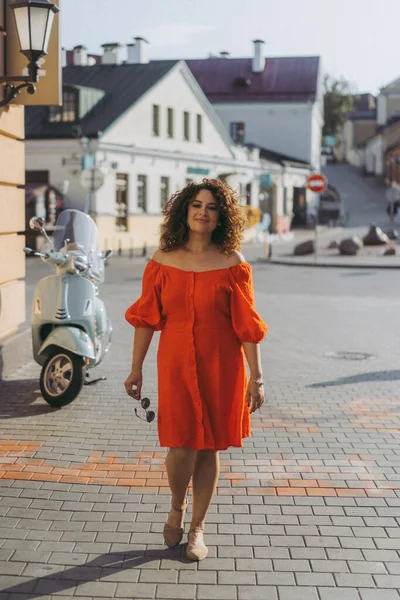 Kıvırcık Siyah Saçlı Kırmızı Elbiseli Güzel Bir Kadın Şehirde Dolaşıyor — Stok fotoğraf