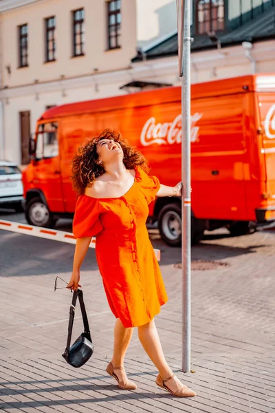 秋の日には赤いドレスを着た美しい女性が街を歩いています — ストック写真