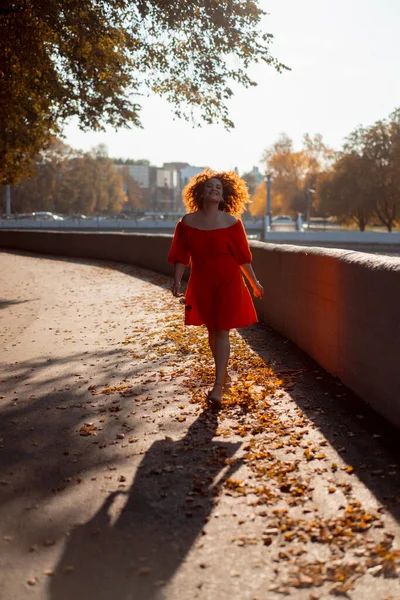 Krásná Žena Kudrnatými Tmavými Vlasy Červených Šatech Prochází Podzimním Městem — Stock fotografie