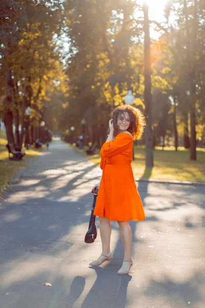 Piękna Kobieta Kręconymi Ciemnymi Włosami Czerwonej Sukience Spaceruje Jesiennym Mieście — Zdjęcie stockowe