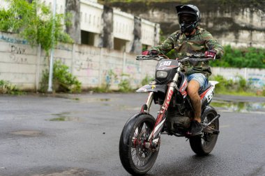 Koruyucu kask ve gözlük takan motosikletli bir adam. Sürücü teçhizatı.